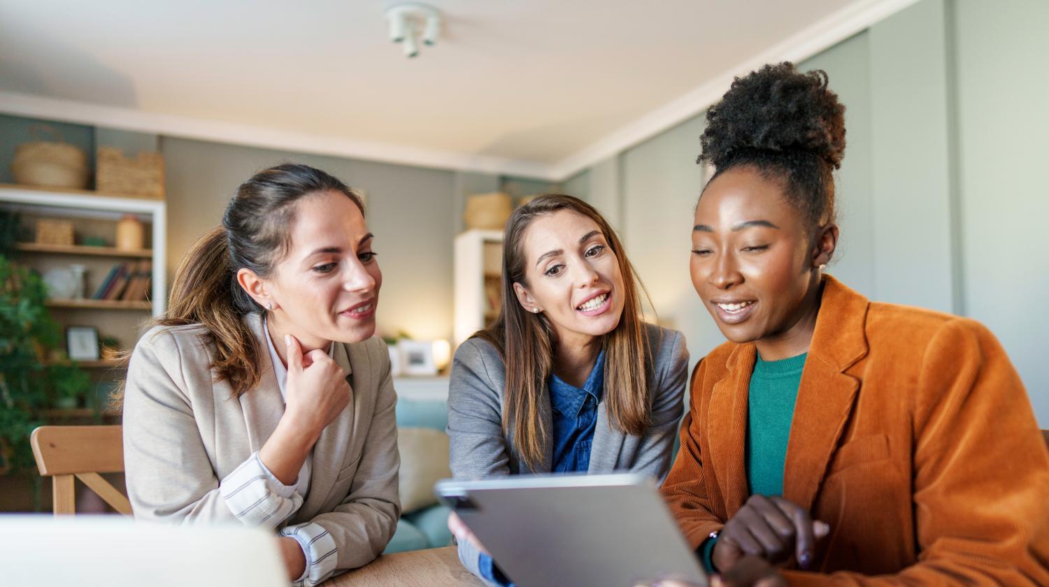 Three women looking at a tablet