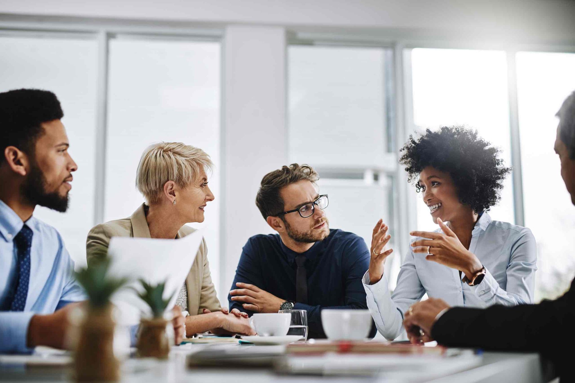 Close-up of four businessmen and women in discussion. Disgruntled current and former employees can become malicious insiders.