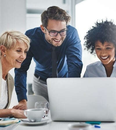 Diverse group of people looking at laptop.