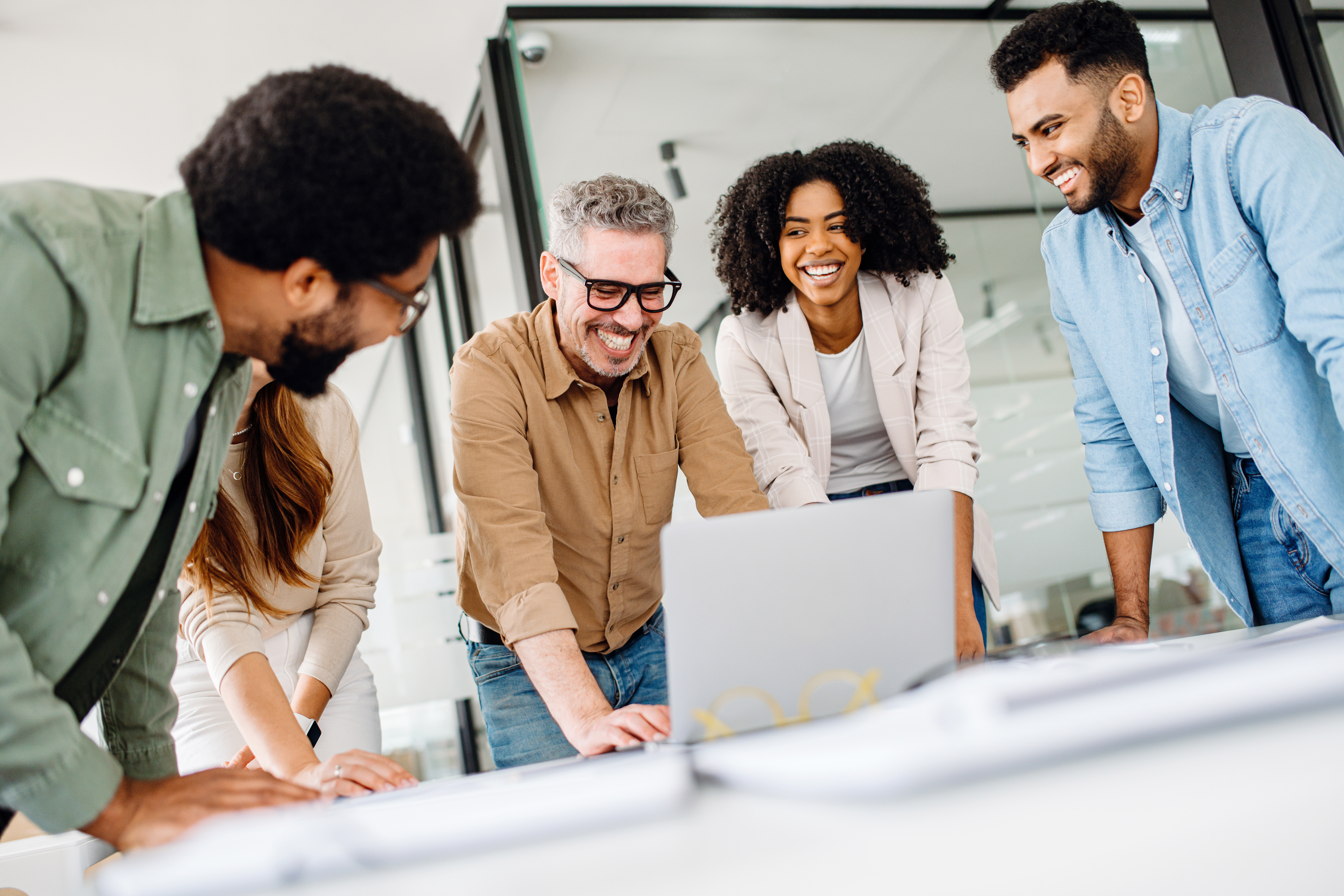 Happy team looking at laptop